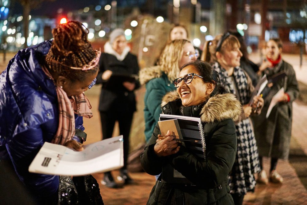 Participants of a nightly art walk talking to each other.