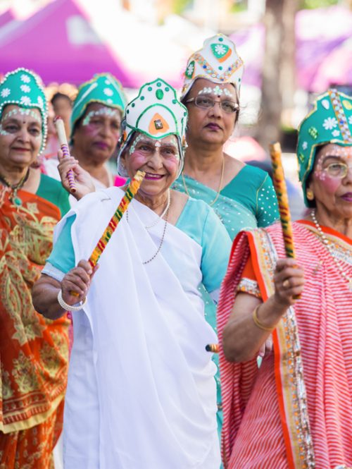 A group of ladies in traditional dress are dancing on the street.