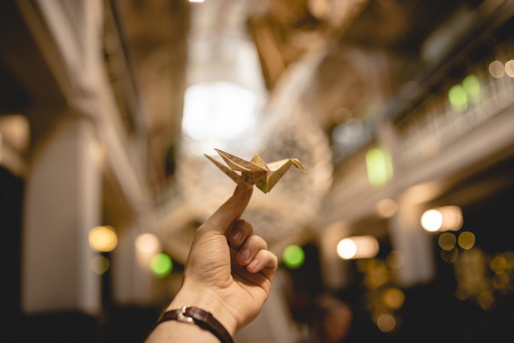 A hand holding an origami bird.