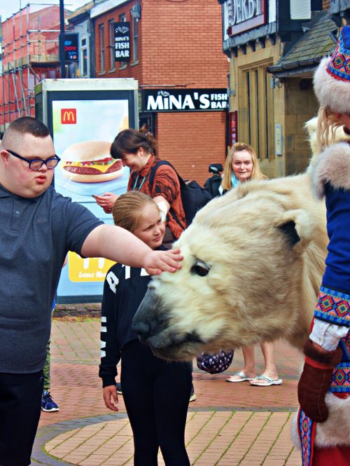 A giant animated puppet of a white polar bear and his keeper perform at Liberty UK Festival.