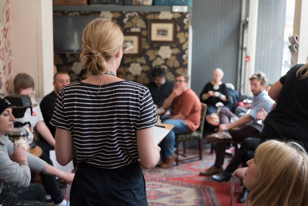 A person speaking to a group of people sitting together.