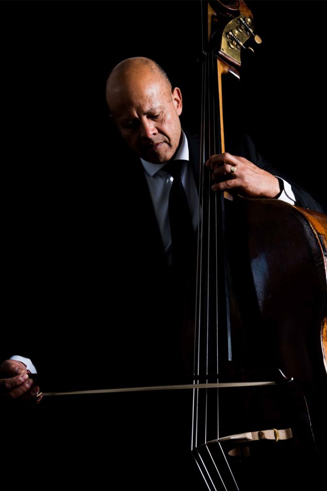 Leon Bosch playing the double bass in front of a black background.