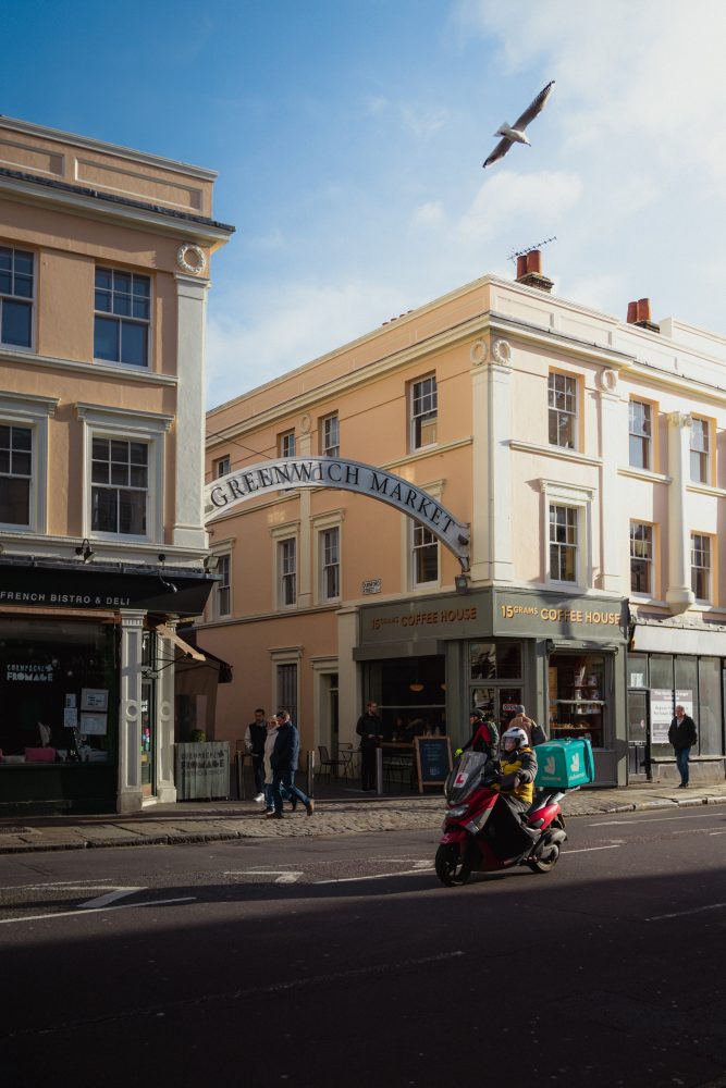 A scooter drives passed the archway of Greenwich market.