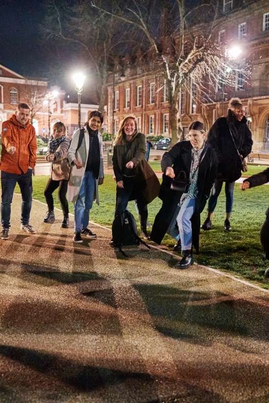 Participants of The Leicester Midnight Run dancing in front of Town Hall Square by night