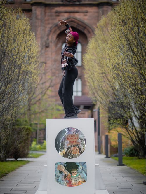 A dancer performing on a raised platform in a park.