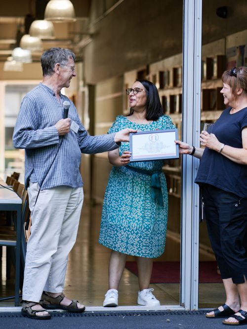 A man is giving a certificate to two women.