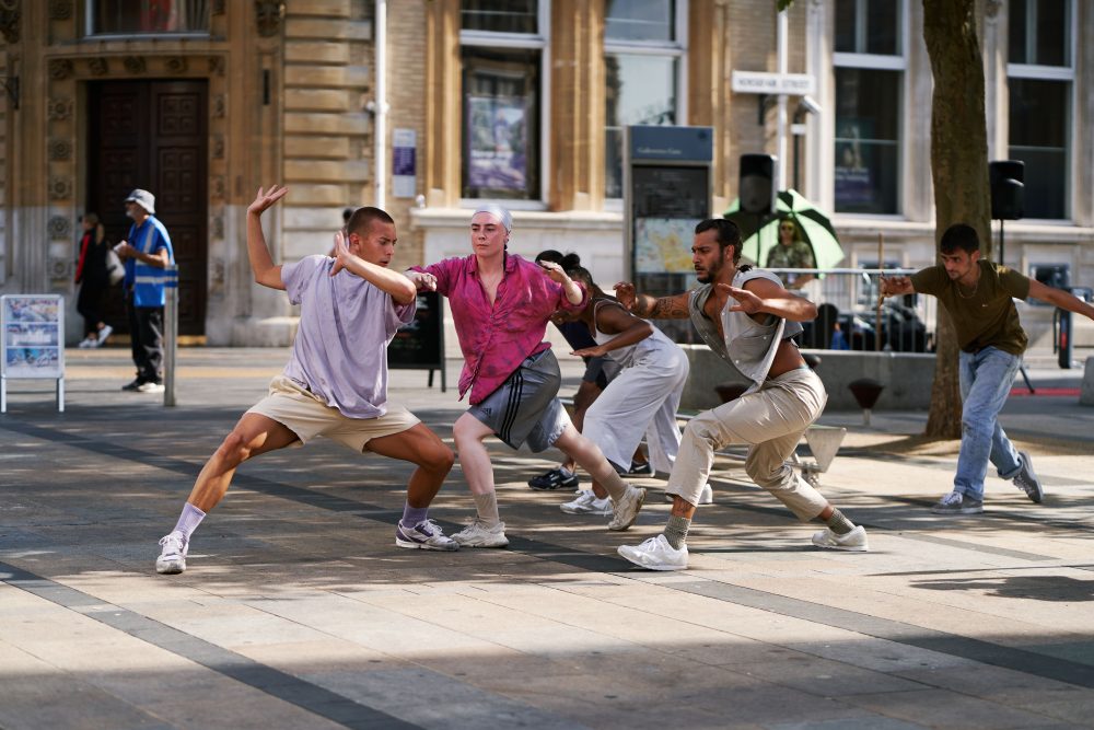 A group of dancers performing on an outdoor square.