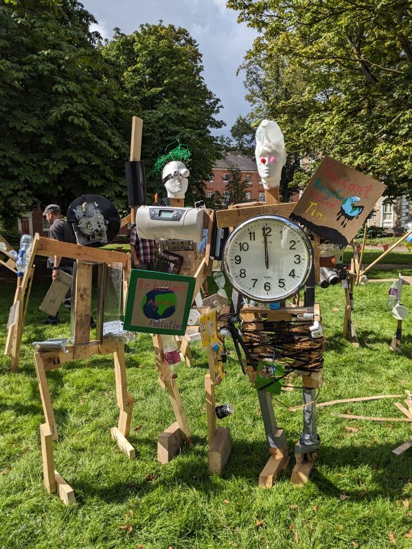 Three junk sculptures standing together in a park.