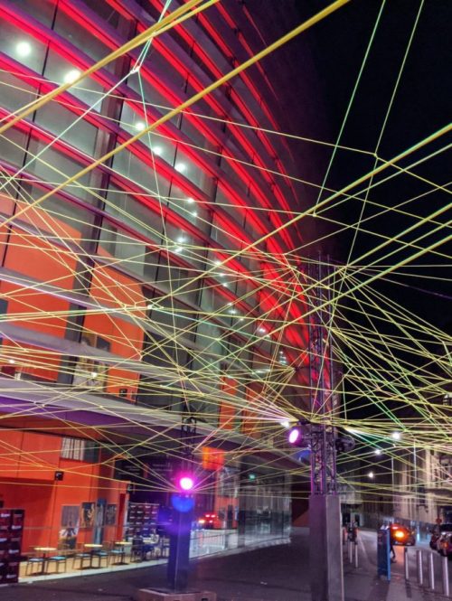 A light installation outside Curve Theatre in Leicester. Glow in the dark string illuminates the sky like a giant web.