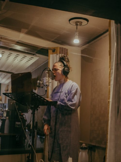 Artist Debris Stevenson recording a song in the studio.