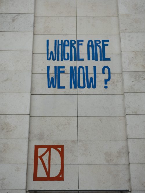 Words, made from felt, that read 'Where are we now?' are displayed on a wall.