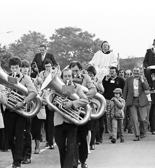 A black and white image of a marching brass band in Corby from 1982.